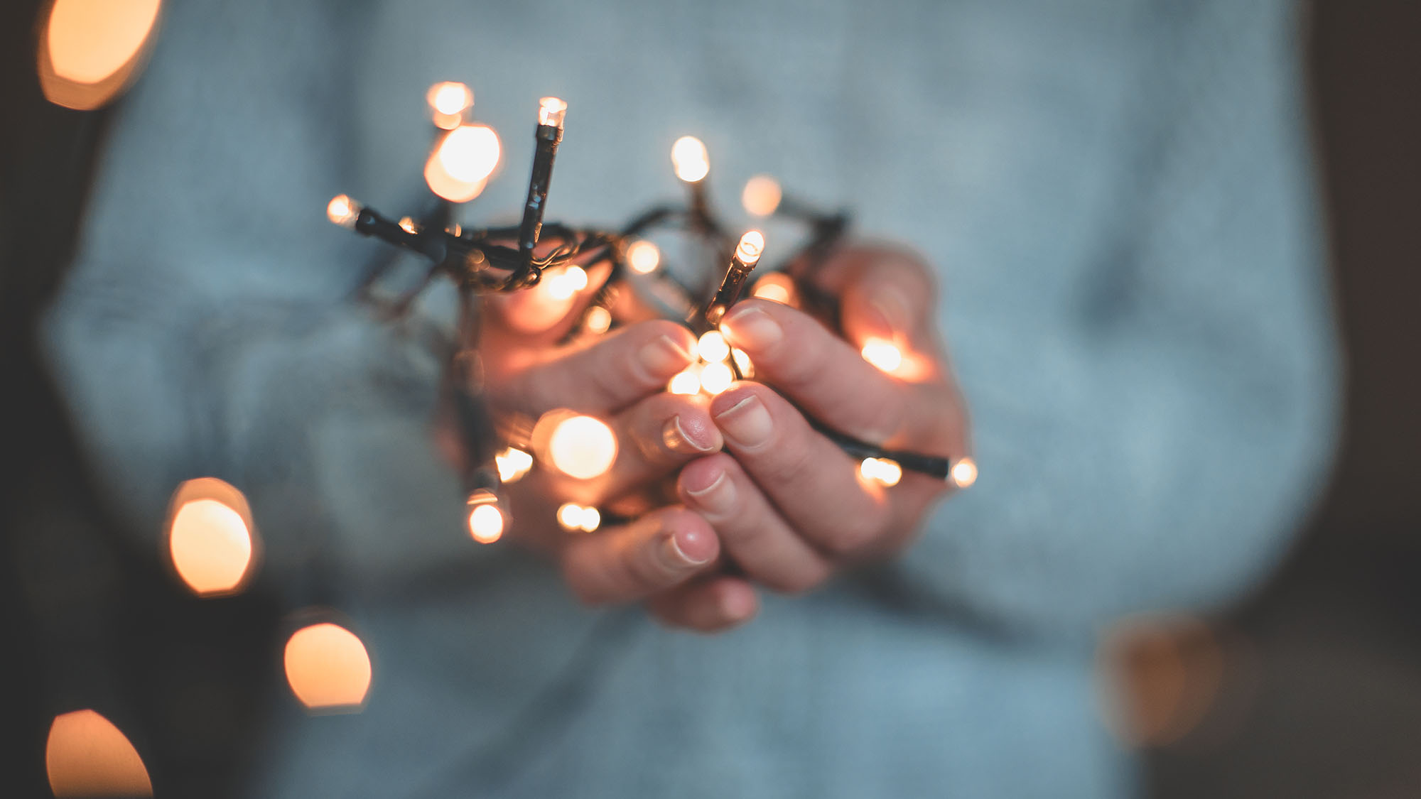 Eine Frau hält eien Lichterkette in ihren Händen