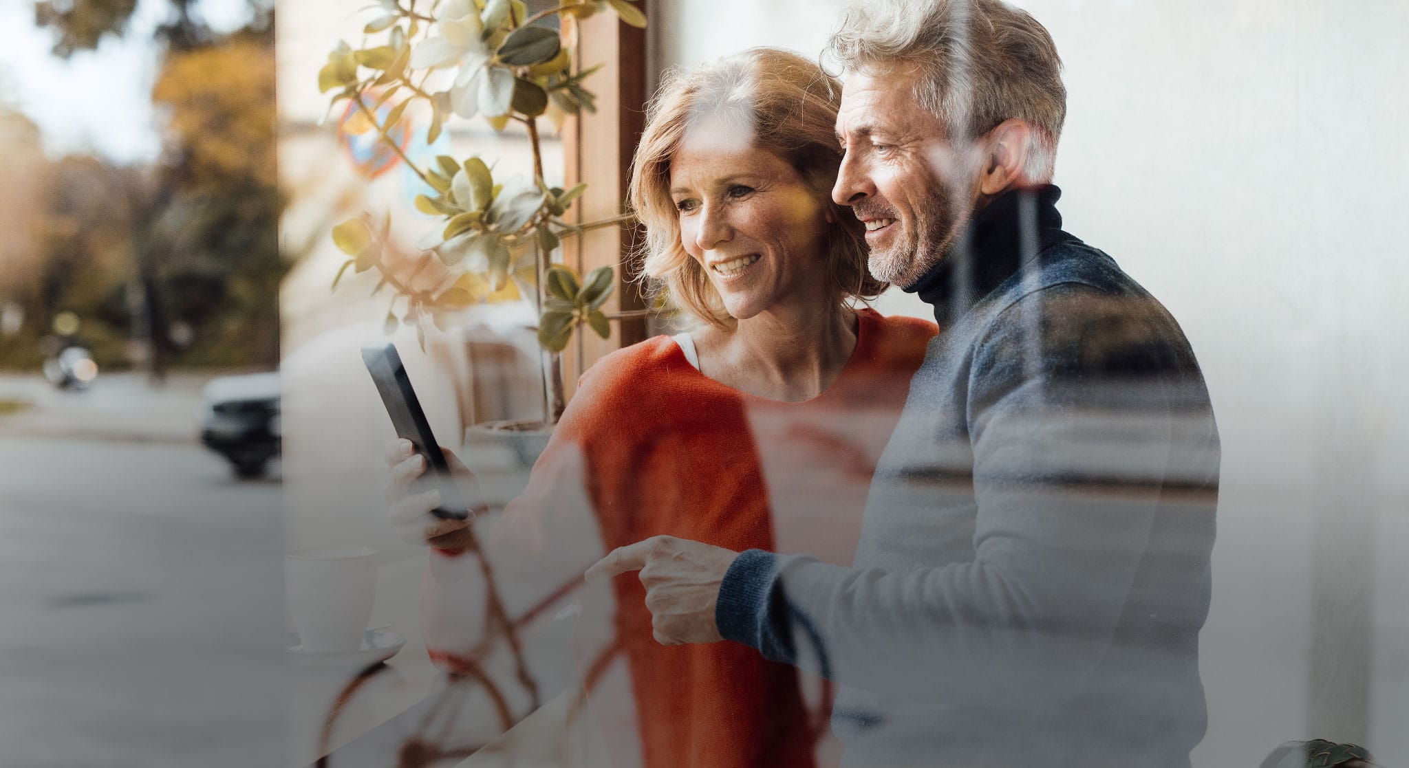 Eine Frau und ein Mann schauen auf ein Handy