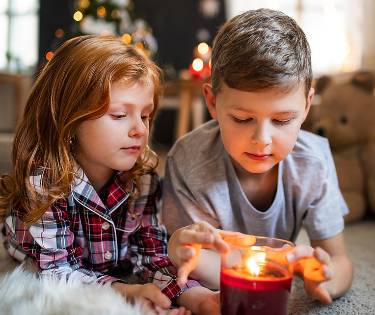 Kinder spielen mit einer Kerze