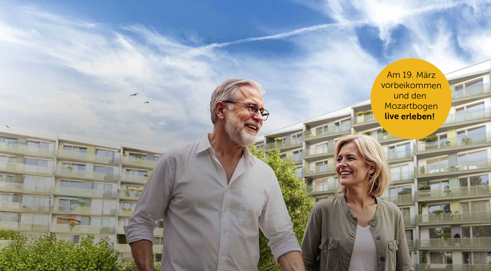 Ein älteres Paar spaziert und hinter ihnen erstrahlt sich der Mozartbogen