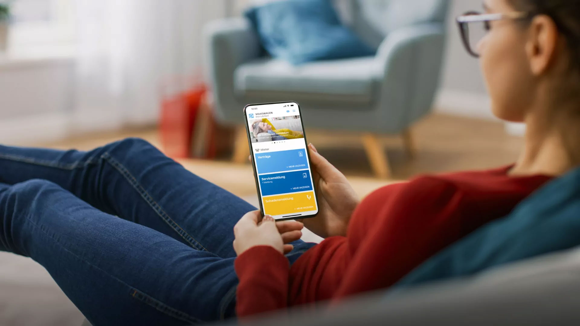 Frau liegt auf dem Sofa und schaut in die Mein VWI-App