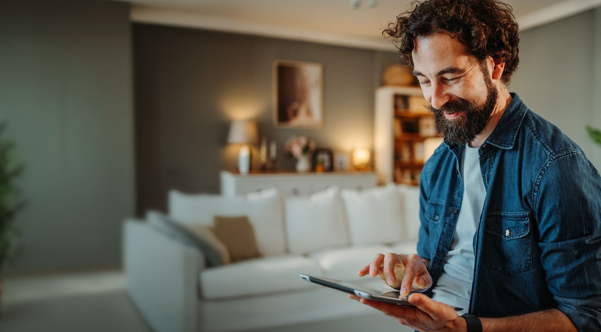 Mann mit Tablet in einem Wohnzimmer